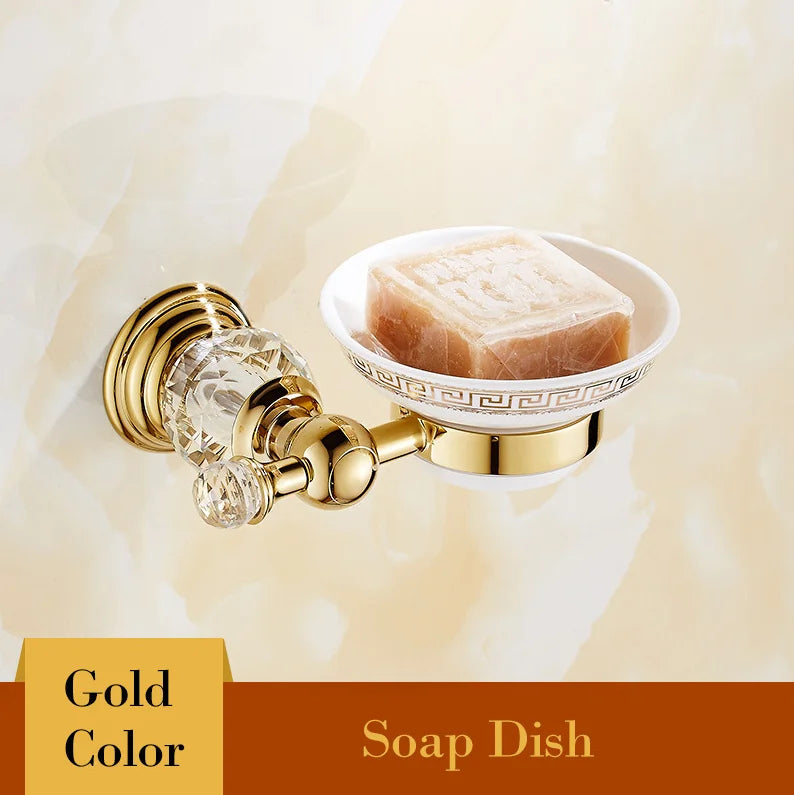 Gold wall-mounted soap dish with crystal accents holding bar soap, luxury bathroom accessory