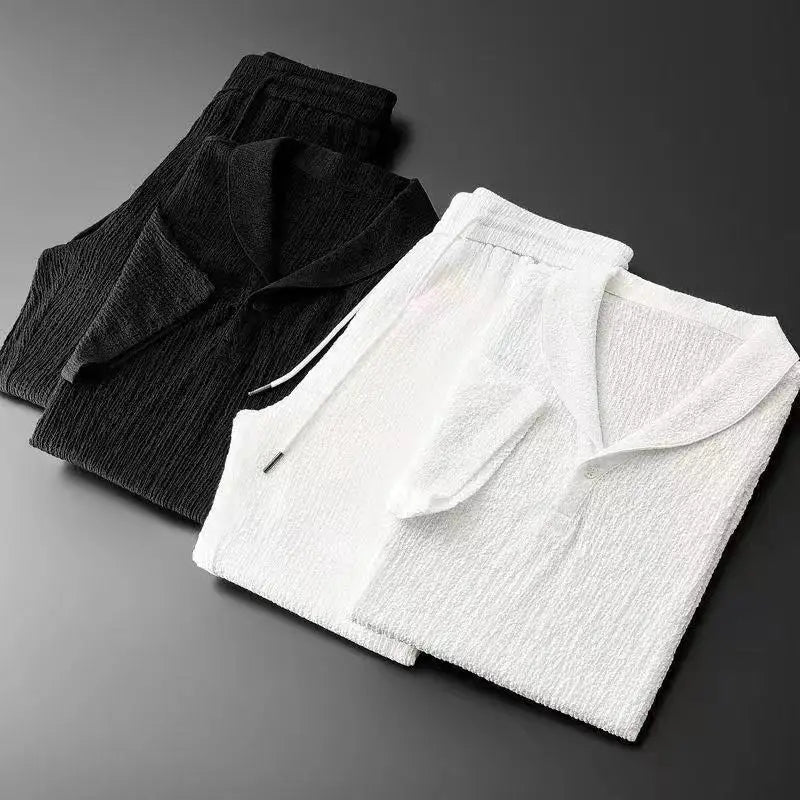 Concierge Tiers loungewear sets in black and white, folded on a dark surface