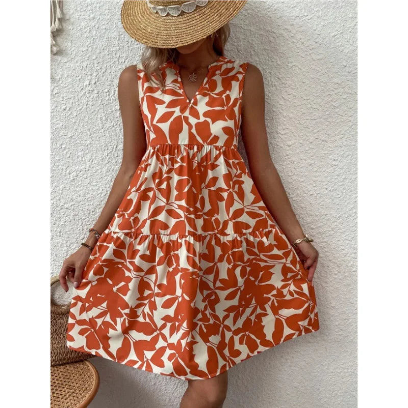 Orange leaf print sleeveless dress with tiered skirt, styled with straw hat for cozy summer vibes