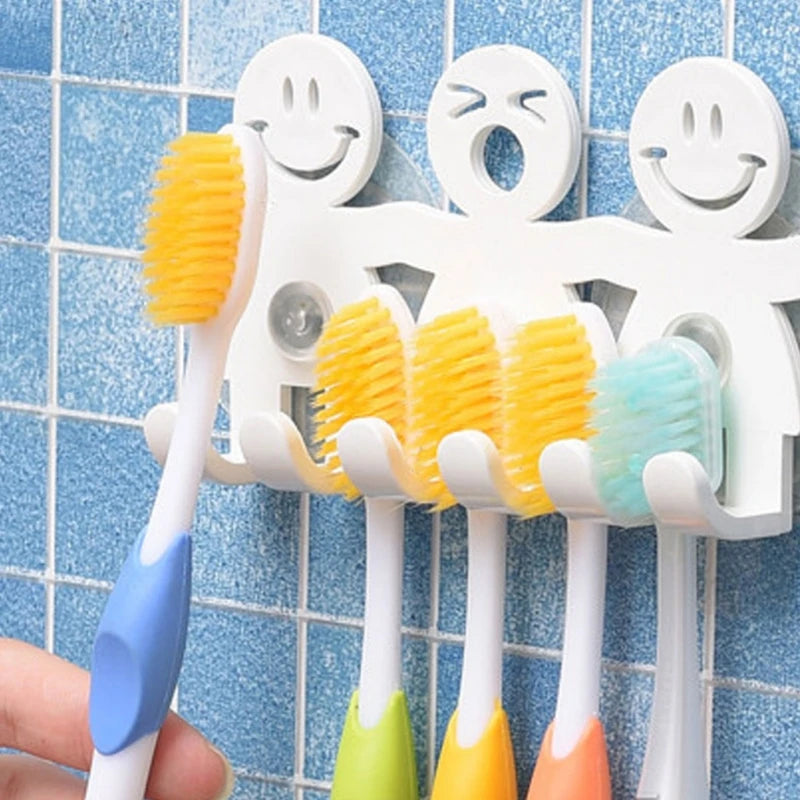 Smiley face toothbrush holder with colorful brushes on blue tile wall