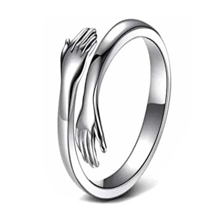 Silver ring with wraparound hands design, symbolizing comfort and care