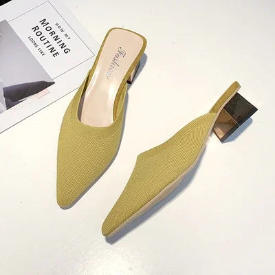 Concierge Tiers showcase featuring stylish yellow woven slip-on mule slippers with block heels on a white background.
