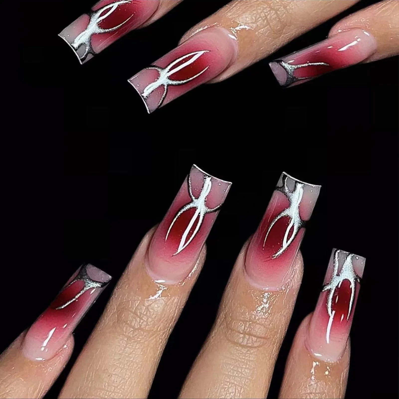 Coffin-shaped ombre nails with red gradient and white abstract design, glossy finish