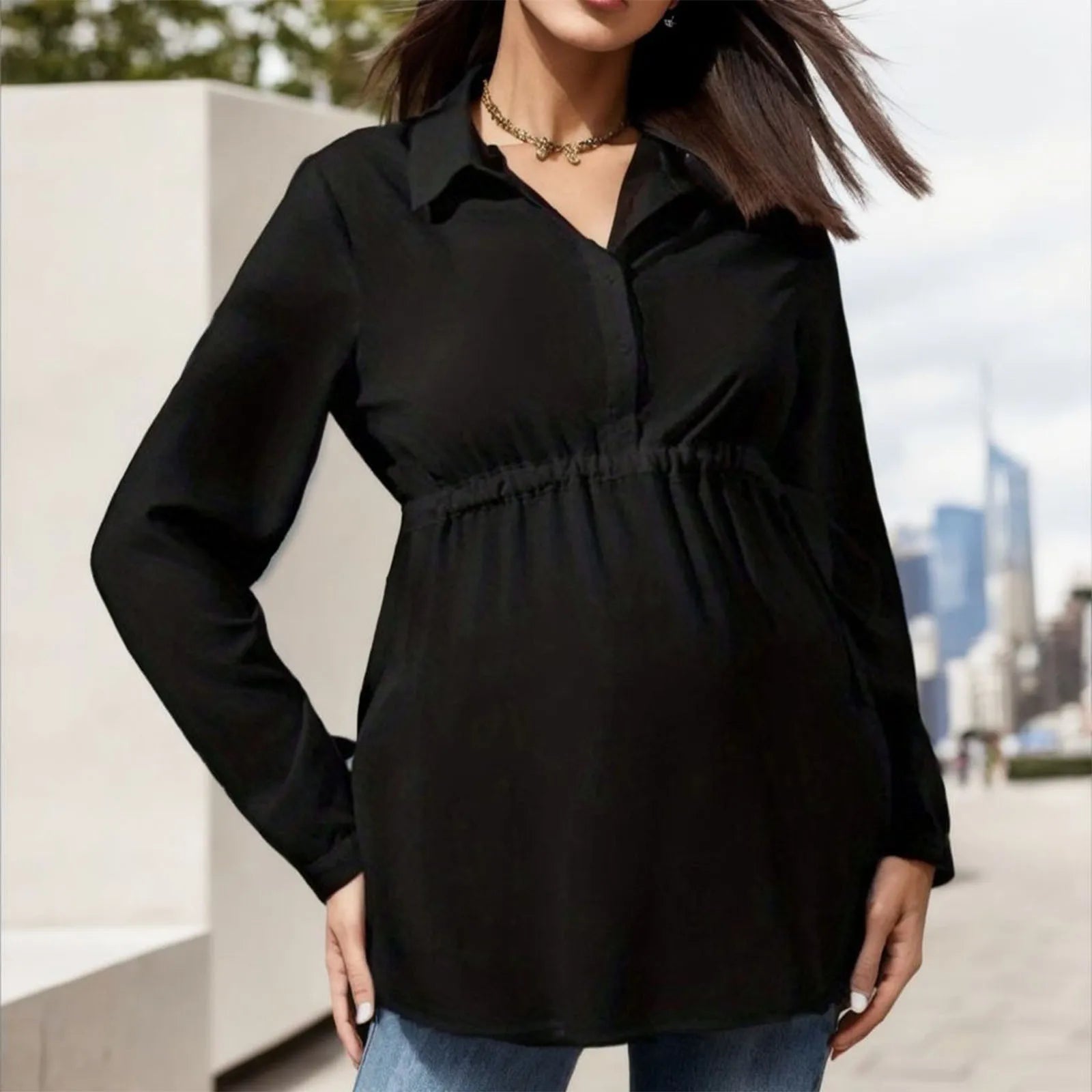 Black maternity shirt with elastic waist, long sleeves, and collared neckline for comfortable everyday wear
