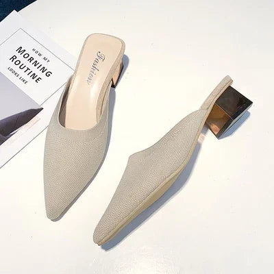 Chic beige mule slippers with pointed toe and metallic block heel, displayed on white surface