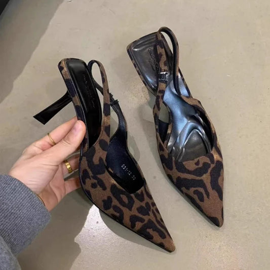 Leopard print slingback heels with pointed toe, displayed on a neutral surface.
