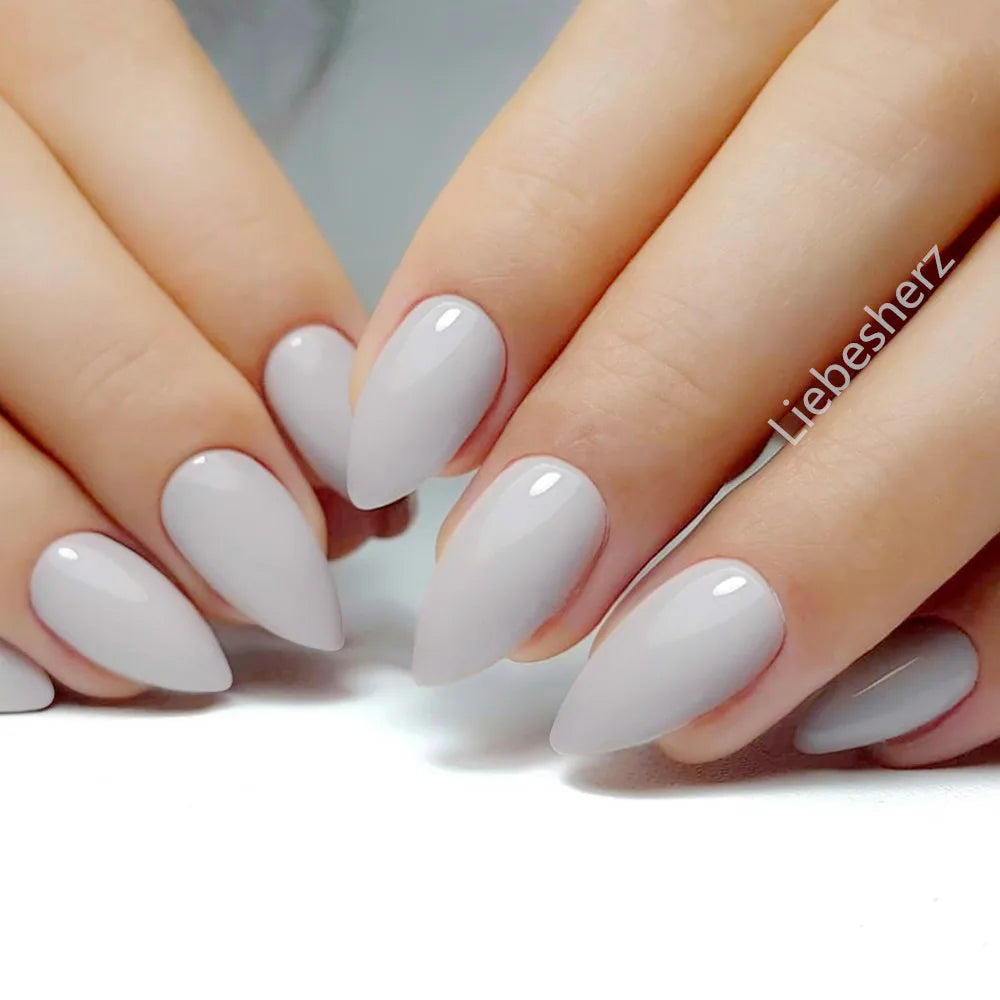 Concierge Tiers display with close-up of hands showing glossy, almond-shaped nude gray nails